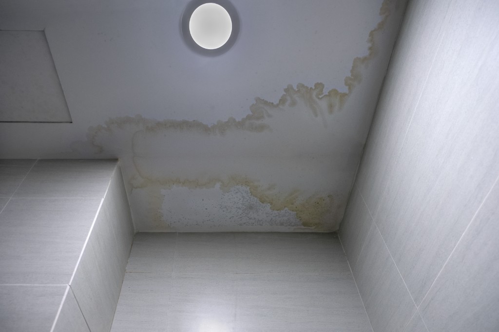 Ceiling water damage from plumbing leaks before repair