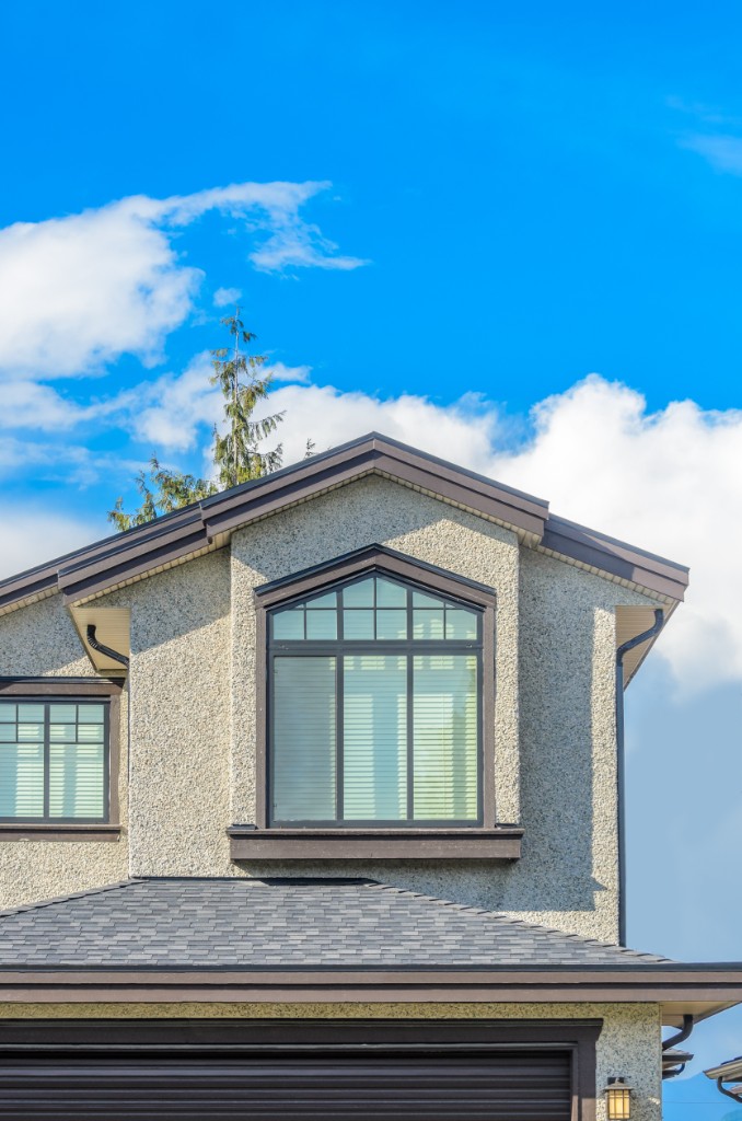 Custom gable window with dark frame against a bright sky